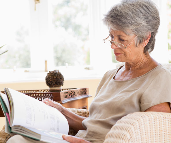 Elderly woman reading a book.