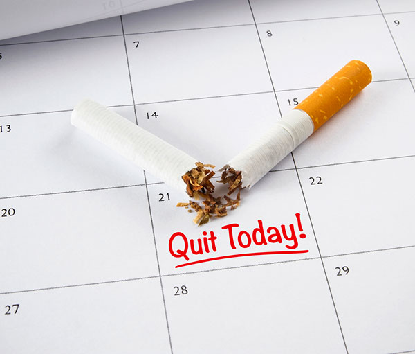 cigarette lying on calender with notation on November 21 to Quit Today.